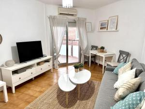 een woonkamer met een bank en een tv bij Preciosas vistas al mar en Castelldefels in Castelldefels