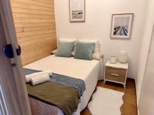 een kleine slaapkamer met een bed en een nachtkastje bij Preciosas vistas al mar en Castelldefels in Castelldefels