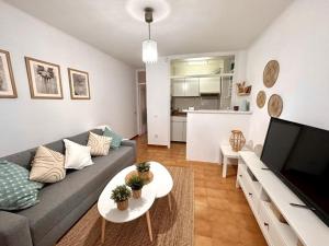 een woonkamer met een bank en een tafel bij Preciosas vistas al mar en Castelldefels in Castelldefels