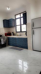 a kitchen with blue cabinets and a white refrigerator at Zanzibar Town house in Ngambo