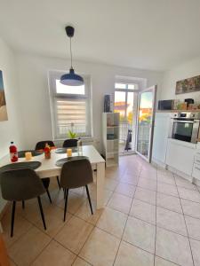 eine Küche und ein Wohnzimmer mit einem Tisch und Stühlen in der Unterkunft Gemütliche 3-Zimmer Ferienwohnung in Leipzig 1 OG in Leipzig