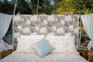 a bed with a headboard with white flowers on it at Il Cantico Bubble Room Home Restaurant in San Giacomo