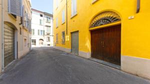 een leeg steegje met een geel gebouw en een garage bij Pitti Home in Reggio Emilia