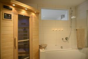 a bathroom with a shower and a tub and a sink at Ferienwohnung OstseeBrise in Olpenitz +14 photos