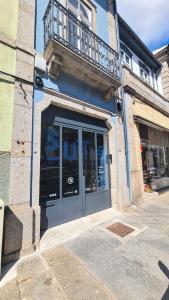 a blue building with a balcony above a door at SUTRooms in Braga