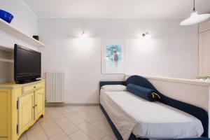 a room with a couch and a flat screen tv at Appartamento La Corte del Pozzo in Vallio Terme