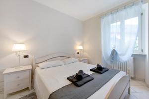 una camera da letto bianca con un letto e asciugamani di Appartamento La Corte del Pozzo a Vallio Terme