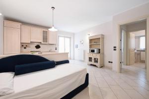 a bedroom with a large bed and a kitchen at Appartamento La Corte del Pozzo in Vallio Terme
