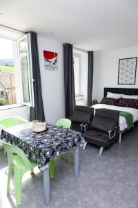 sypialnia z łóżkiem, stołem i krzesłami w obiekcie LA BATISSE l'arbre gris w mieście Le Grand-Abergement