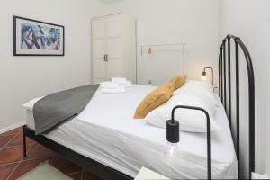 um quarto com uma cama grande e lençóis brancos em Apartment FERIA 1 em Opatija