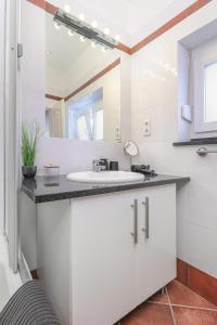 a white bathroom with a sink and a mirror at Apartment FERIA 1 in Opatija