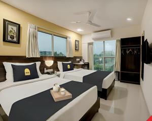 a bedroom with two beds and a window at Leo Hotel in Ahmedabad