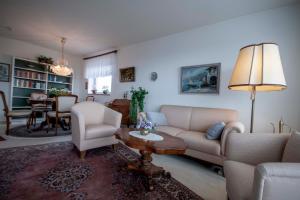 uma sala de estar com um sofá, cadeiras e uma mesa em Frische Brise FeWo 12 01 em Cuxhaven