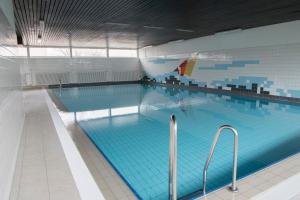 uma grande piscina interior com água azul em Frische Brise FeWo 12 01 em Cuxhaven