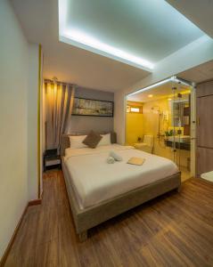 a bedroom with a large bed and a bathroom at Cactusland Boutique Hotel in Ho Chi Minh City