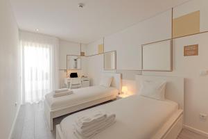 a white room with two beds and a desk at Uporto House Residence in Porto