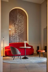 una sala de estar con un sofá rojo y una mesa en Wasserturm Hotel Cologne, Curio Collection by Hilton, en Colonia