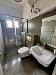 ein Badezimmer mit einem weißen WC und einem Waschbecken in der Unterkunft Mount Bay Guest House in Mount Lavinia