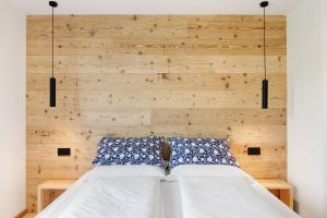a bed with blue and white pillows and a wooden wall at La Villa del lago in Colico +37 photos