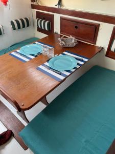 uma mesa de madeira com duas placas azuis em Séjour unique à bord d un voilier em La Rochelle