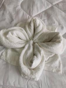 een witte handdoek op een bed bij NST Boutique เอ็นเอสทีบูทีค in Ban Pak Phun