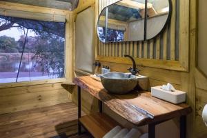 ein Badezimmer mit einem Spülbecken auf einer Holztheke in der Unterkunft Bundox River Lodge in Hoedspruit