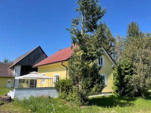 ein gelbes Haus mit einem Baum davor in der Unterkunft Ferienhaus Murtal in Weißkirchen in Steiermark