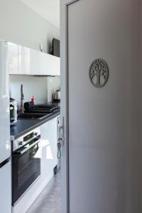 a kitchen with white cabinets and a stove at LA BATISSE l'arbre gris in Le Grand-Abergement