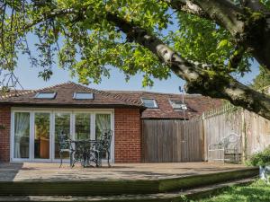 a patio with a table and chairs and a fence at Oast Cottage in Maidstone