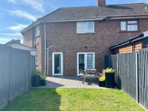 a brick house with a wooden bench in the yard at Brett Stays - Lower King Weston House in Avonmouth