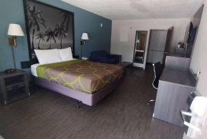 Habitación de hotel con cama y silla en Super 8 Motel by Wyndham near Fort Lauderdale Arpt, en Dania Beach