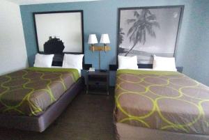 Habitación de hotel con 2 camas y 2 lámparas en Super 8 Motel by Wyndham near Fort Lauderdale Arpt, en Dania Beach