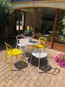 une table, deux chaises, une table et des chaises dans l'établissement Le gîte des Tourterelles, à Belleville-sur-Saône