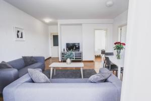 a living room with two blue couches and a table at Cornisa Apartments in Patalavaca