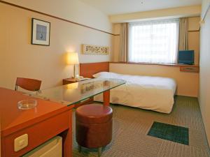 a hotel room with a bed and a glass desk at Hotel Lexton Kagoshima in Kagoshima