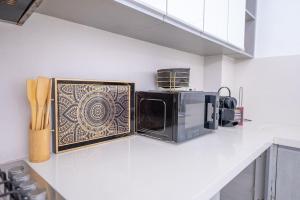 cocina con microondas en la encimera en Tradition Meets Modern: 2BR Flat in Rabat Hassan, en Rabat