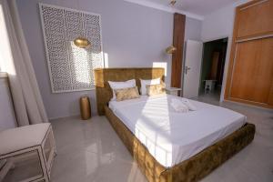 a bedroom with a large bed with white sheets at Tradition Meets Modern: 2BR Flat in Rabat Hassan in Rabat
