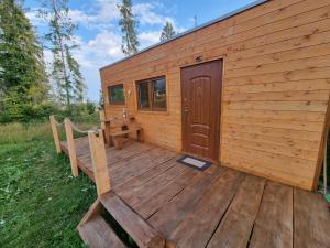 une cabine avec une terrasse en bois et une porte dans l'établissement Domčok pod Tatrami, à Važec