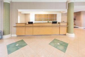 a large lobby with a waiting room with a desk at La Quinta by Wyndham Tampa Brandon Regency Park in Brandon