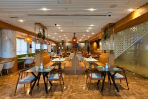 a restaurant with tables and chairs and a couch at The First Collection Dubai Marina in Dubai