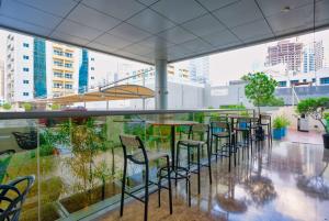 a bar with chairs and tables on a balcony at The First Collection Dubai Marina in Dubai