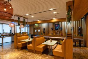 a restaurant with two tables and yellow chairs at The First Collection Dubai Marina in Dubai