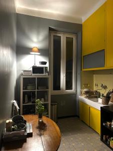 une cuisine avec des armoires jaunes et une table en bois dans l'établissement Appartement de charme Rue Paradis, à Marseille