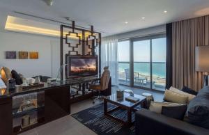 杜拜的住宿－溫德姆杜拜碼頭飯店，客厅配有沙发和电视。