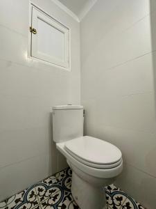La salle de bains blanche est pourvue de toilettes et d'une fenêtre. dans l'établissement Appartement de charme Rue Paradis, à Marseille
