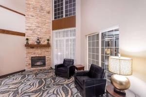 a living room with two chairs and a fireplace at Wyndham Garden Madison Fitchburg in Madison