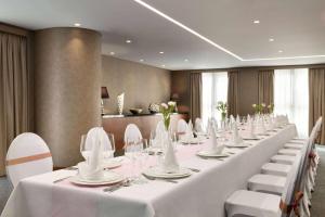 a long table with white tables and white chairs at The First Collection Dubai Marina in Dubai