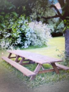 a wooden picnic table sitting in a park at Chez Tobi in Bazincourt-sur-Epte