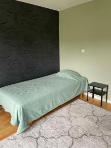 a bedroom with a bed and a side table at Cozy Rooms between Airport&Center in Stockholm