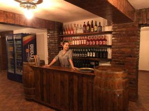 a woman standing behind a bar in a wine cellar at Pensiunea La Conac in Bîrlad